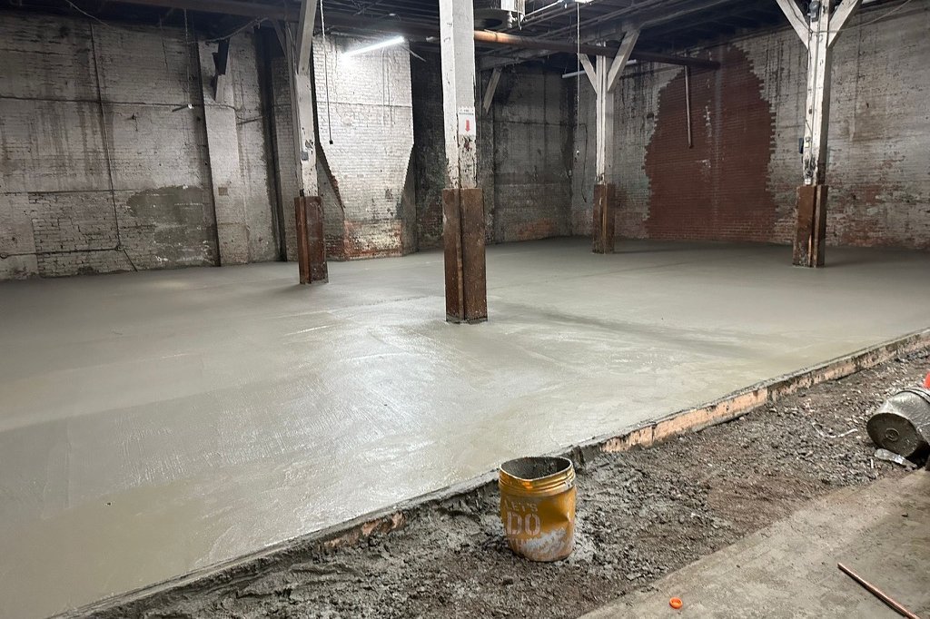 Newly poured, level concrete sidewalk in front of a NYC brownstone stoop